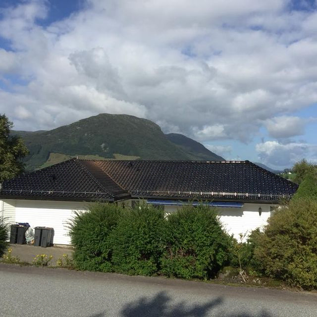 Tak på hus vises over hekk